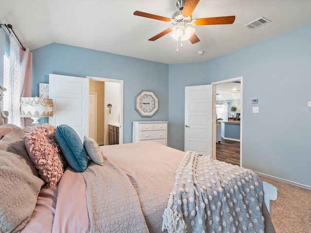 carpeted bedroom with ensuite bath, ceiling fan, and lofted ceiling