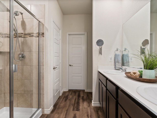 bathroom with hardwood / wood-style floors, vanity, and a shower with shower door