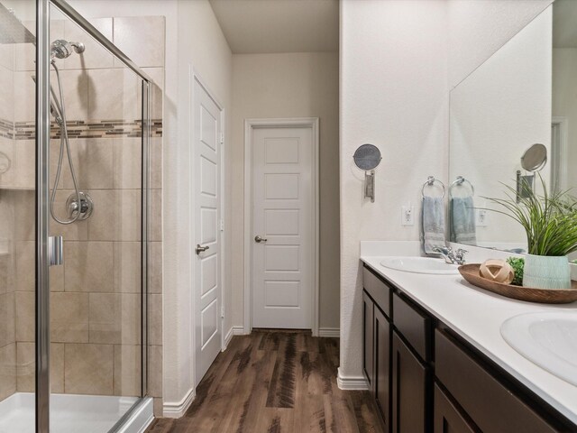 bathroom with vanity, hardwood / wood-style floors, and a shower with door