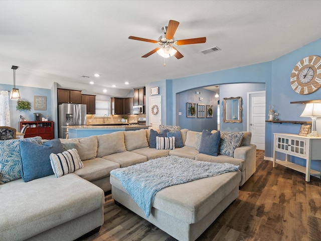 living room with ceiling fan, sink, and dark wood-type flooring