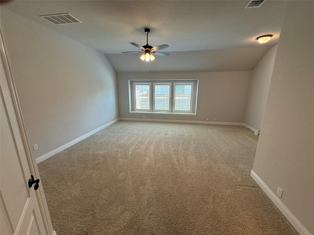 carpeted spare room featuring ceiling fan and lofted ceiling