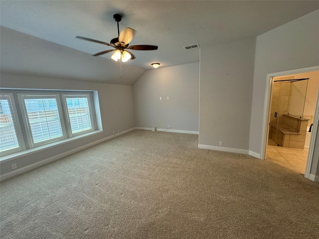 empty room with light carpet, ceiling fan, and vaulted ceiling