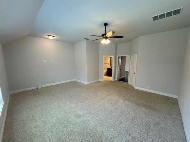 carpeted spare room featuring vaulted ceiling and ceiling fan