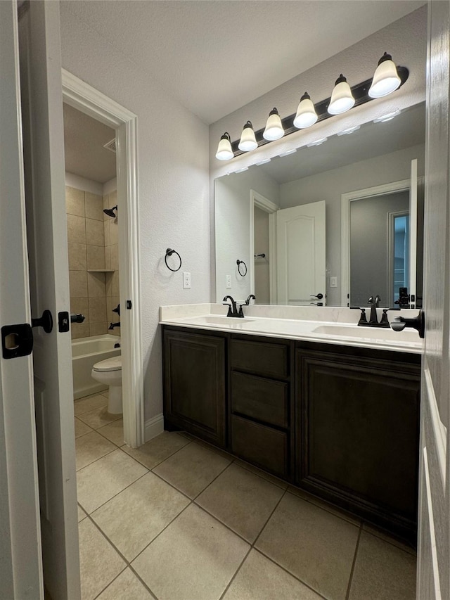 full bathroom featuring tile patterned floors, vanity, tiled shower / bath combo, and toilet