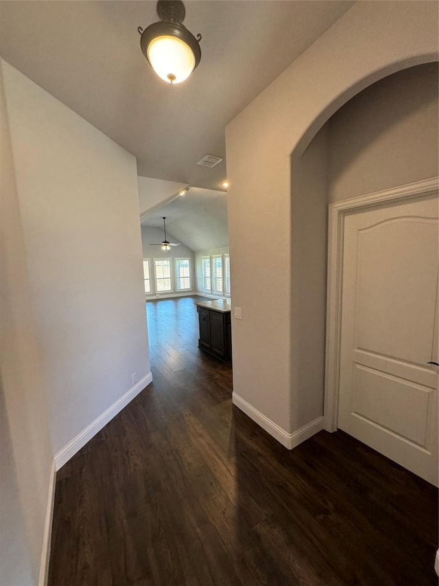 corridor featuring dark hardwood / wood-style flooring and vaulted ceiling