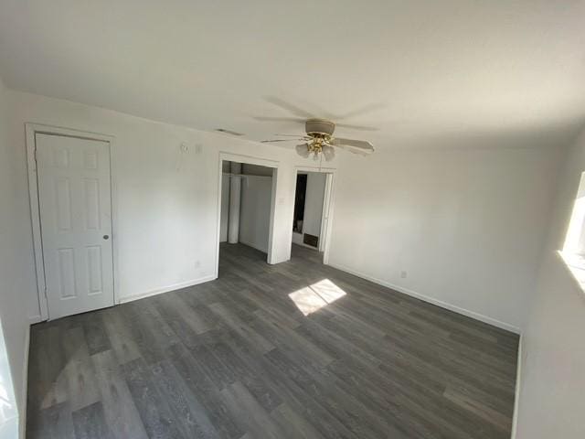 spare room with dark hardwood / wood-style flooring and ceiling fan