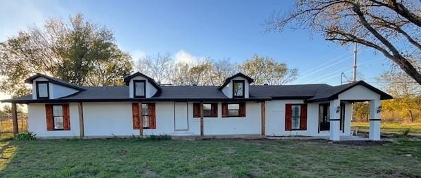 rear view of house featuring a yard