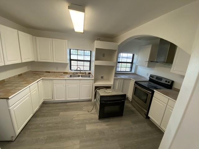 kitchen featuring white cabinetry, sink, a kitchen island, and electric range