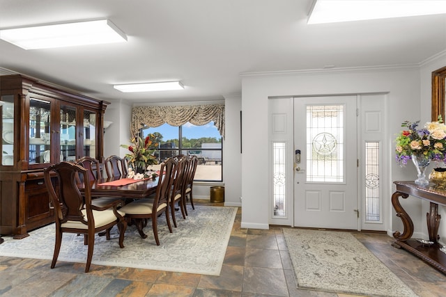 dining space featuring a healthy amount of sunlight, crown molding, and dark tile patterned flooring