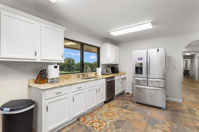 kitchen with white cabinetry, appliances with stainless steel finishes, sink, and ornamental molding