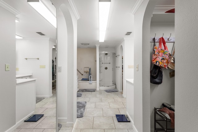 hallway featuring ornamental molding and light tile patterned floors