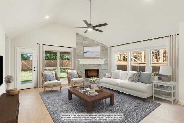 living room with a fireplace, high vaulted ceiling, light wood-type flooring, and ceiling fan