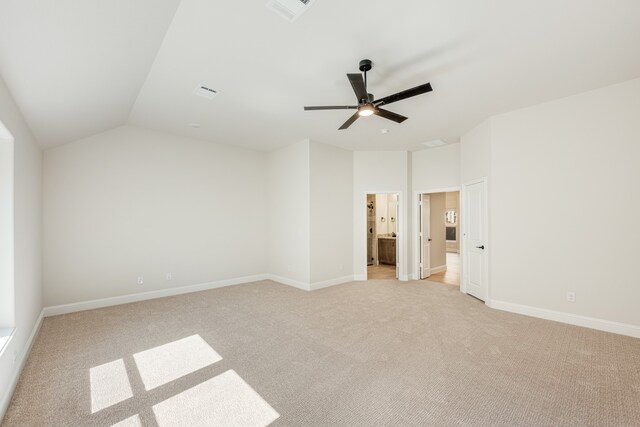 unfurnished bedroom featuring ceiling fan, light carpet, lofted ceiling, and ensuite bath