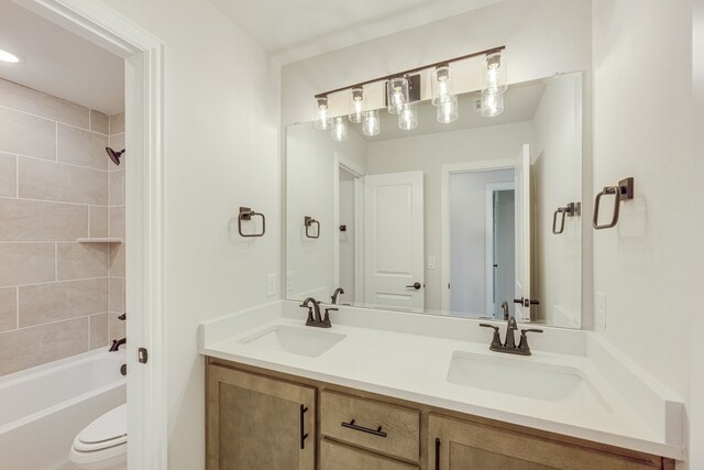 full bathroom with vanity, toilet, and tiled shower / bath