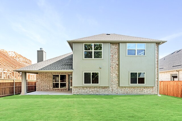 rear view of property with a patio area and a lawn