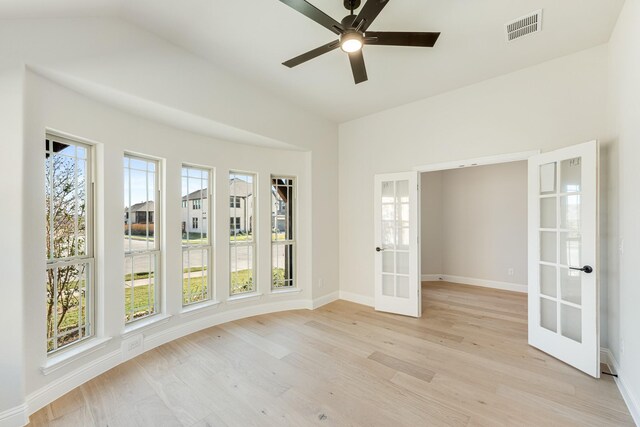 spare room featuring a ceiling fan, french doors, baseboards, visible vents, and light wood-type flooring