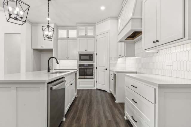 kitchen with premium range hood, white cabinetry, sink, a kitchen island with sink, and stainless steel appliances