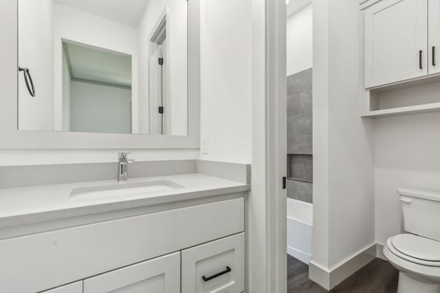 full bathroom with wood-type flooring, vanity, shower / bathtub combination, and toilet