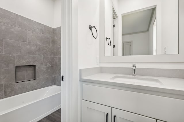 bathroom with tiled shower / bath combo and vanity