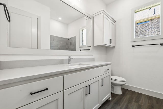 bathroom with hardwood / wood-style flooring, a shower, vanity, and toilet