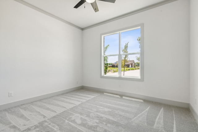 spare room featuring light carpet, crown molding, and ceiling fan