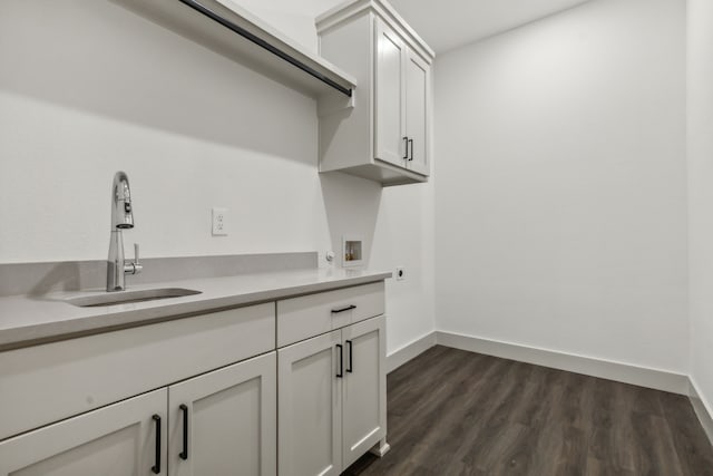 washroom with sink, electric dryer hookup, dark hardwood / wood-style floors, cabinets, and washer hookup