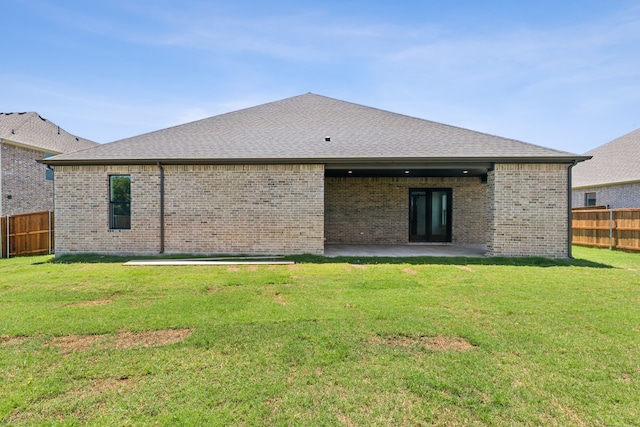 back of property with a yard and a patio area