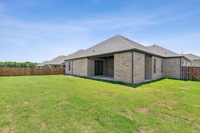 back of house with a lawn and a patio area