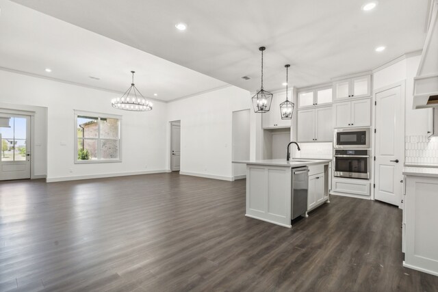 kitchen featuring a kitchen island with sink, decorative light fixtures, stainless steel appliances, and white cabinets