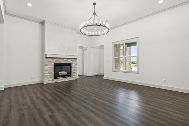 unfurnished living room featuring crown molding, a fireplace, dark hardwood / wood-style flooring, and a chandelier