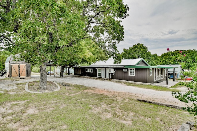 view of front facade with a front yard and a shed