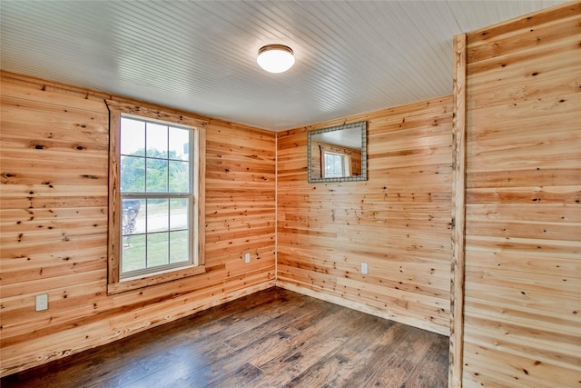 unfurnished room featuring wood-type flooring and wooden walls