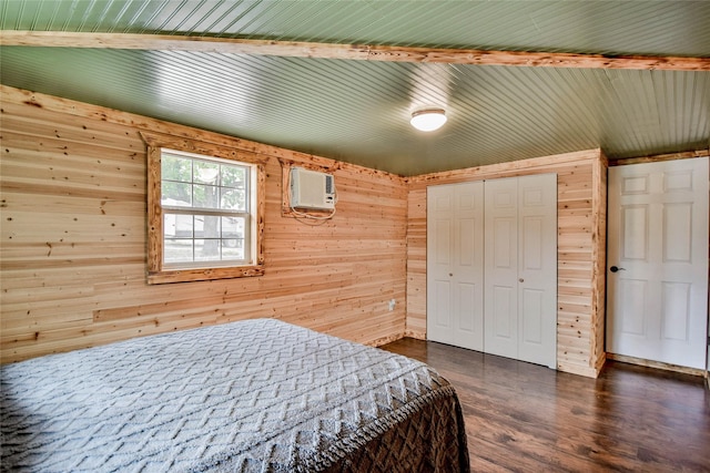 bedroom featuring hardwood / wood-style flooring, wooden walls, a closet, and a wall mounted air conditioner