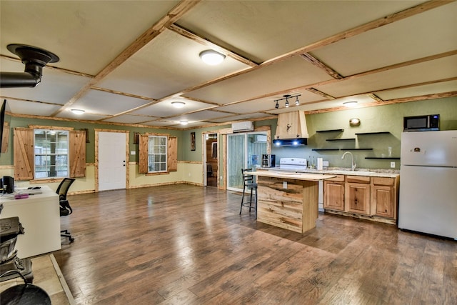 kitchen featuring dark wood-type flooring, a breakfast bar, white appliances, and light brown cabinetry