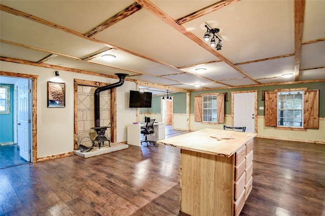 kitchen featuring a center island, a wood stove, dark hardwood / wood-style flooring, and plenty of natural light