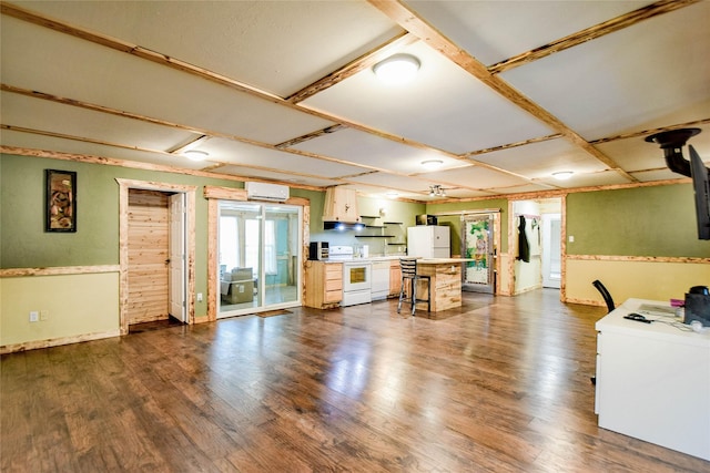 kitchen featuring a kitchen bar, white appliances, dark wood-type flooring, white cabinets, and an AC wall unit