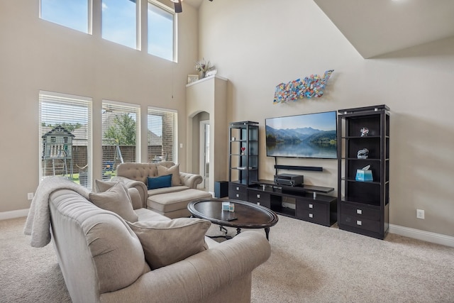 carpeted living room with a high ceiling