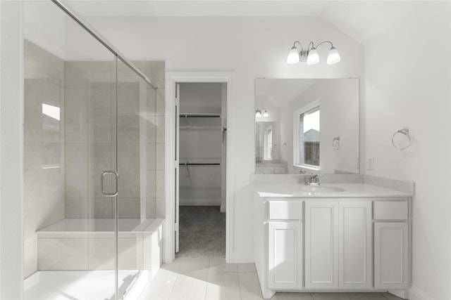 bathroom featuring tile patterned flooring, vanity, walk in shower, and lofted ceiling