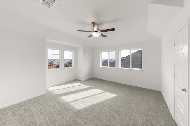 spare room with ceiling fan, a healthy amount of sunlight, and light carpet