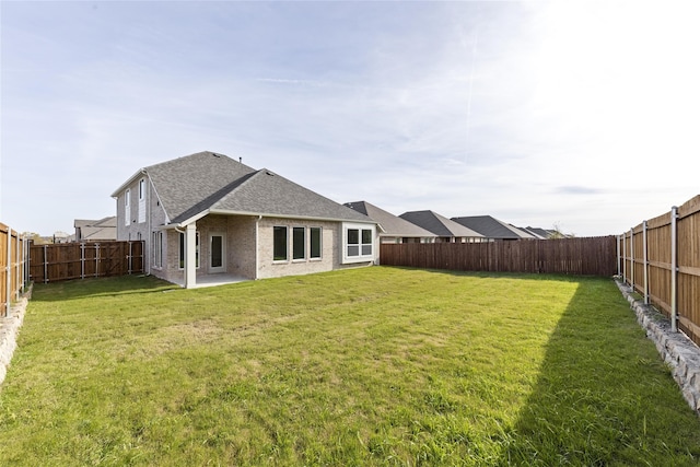 rear view of house featuring a lawn and a patio