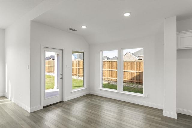 doorway to outside with hardwood / wood-style floors and vaulted ceiling