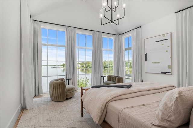 bedroom with a notable chandelier, vaulted ceiling, and a water view