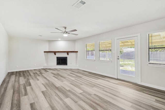 unfurnished living room with light wood-type flooring, ceiling fan, and a textured ceiling