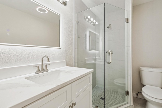 bathroom featuring an enclosed shower, vanity, and toilet