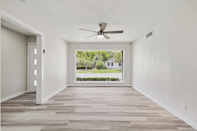 empty room featuring ceiling fan and light hardwood / wood-style floors