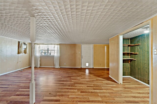 interior space with hardwood / wood-style flooring, a wall mounted AC, and brick ceiling