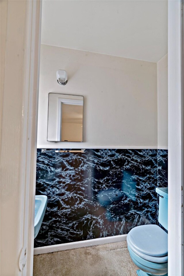 bathroom with tile walls and toilet