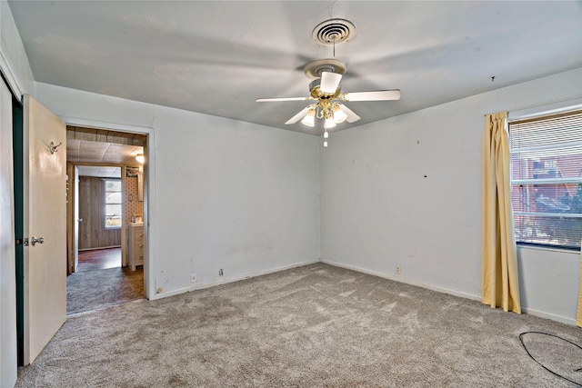 carpeted spare room with ceiling fan