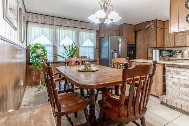 dining room featuring a chandelier, light tile patterned floors, and a textured ceiling