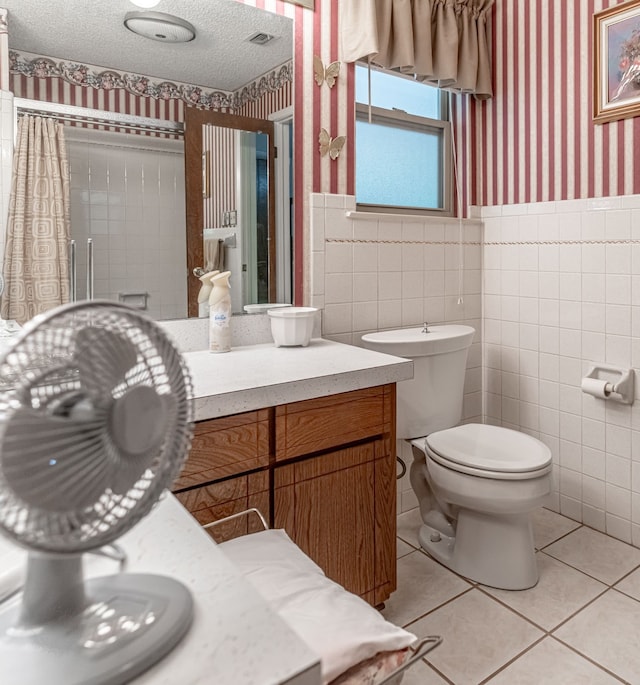 bathroom with vanity, tile walls, toilet, and tile patterned flooring